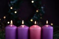 Close-up of four burning purple advent candles
