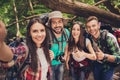 Close up of four cheerful friends in the summer nice wood, embracing, posing for a selfie shot, that beautiful brunette lady is t