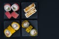 Close-up, on four containers are assorted Japanese rolls, tuna, with soft cheese and teriyaki sauce and baked rolls in tempura,