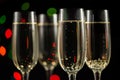 Close-up, four flutes with sparkling wine over Christmas multicolored background.