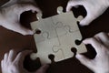 Close-up of four hands holding a jigsaw puzzle, concept for team building success Royalty Free Stock Photo