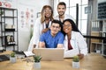 Close up of four international doctors with gadgets at modern office in clinic Royalty Free Stock Photo