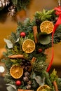 close-up of fragment of beautiful wreath decorated with dry orange slices balls and ribbon