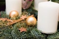 Christmas wreath from fresh green fir tree branches decorated with golden star ornaments baubles cinnamon sticks white candles Royalty Free Stock Photo