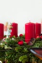 Close up fragment of Christmas wreath from fresh green fir tree branches decorated with red ornament baubles angel figure garland Royalty Free Stock Photo