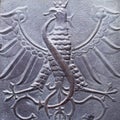 Close up fragment of medieval metal doors with eagle and snake, Poland. Part of antique old door Royalty Free Stock Photo