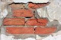 Fragment of old red brick wall with falling off cement textured background Royalty Free Stock Photo