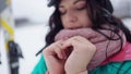 Close-up of freezed female slim hands with blurred beautiful woman exhaling at background. Positive young female tourist