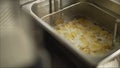 Close up French Fries Potatoes cooking in basket of Frying Machine , deep fried in Hot Boiling Oil Royalty Free Stock Photo