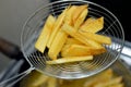 Close up of French fries potatoes fried in boiling hot oil in a deep fryer at home. French fries, Junk food concept, home made Royalty Free Stock Photo