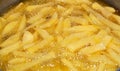 Close-up of French fries potatoes frying in boiling hot oil in a deep fryer at home. French fries, Junk food concept, home made Royalty Free Stock Photo