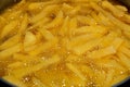 Close-up of French fries potatoes frying in boiling hot oil in a deep fryer at home. French fries, Junk food concept, home made Royalty Free Stock Photo