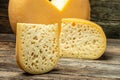 Close up french hard cheese with holes emmentaler on a wooden background. farmer market. place for text Royalty Free Stock Photo