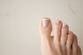 Close-up French pedicure on beautiful female legs. Neat nails after a pedicure procedure on a white background. Space Royalty Free Stock Photo