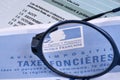 French notice of assessment of property taxes with glasses close-up