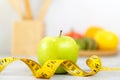 Close up fresh apple and tape measure. Healthy snack for diet planning. Royalty Free Stock Photo