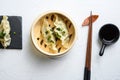 Close up fresh boiled gyoza dumplings in wooden bamboo steamer with soy sauce top view