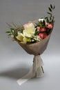 Close-up fresh bouquet of hippeastrum, allium, carnation, ruscus, genista, cotton on a gray background, selective focus