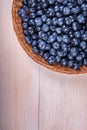 Close-up of fresh and bright blueberry. Healthy, ripe, raw and bright dark blue berries on a wooden background. Copy space. Royalty Free Stock Photo