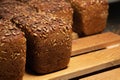 Close-up fresh brown loaves of rye bread in the form of bricks with sunflower seeds on a crust. Lie on a wooden rack Royalty Free Stock Photo