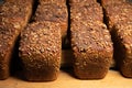 Close-up fresh brown loaves of rye bread in the form of bricks with sunflower seeds on a crust. Lie on a wooden rack Royalty Free Stock Photo