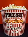 Close up fresh buttery popcorn in a stripped red and white bowl on red background Royalty Free Stock Photo