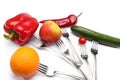 Close up of fresh cherry tomato, red peppers, cucumber, apple and orange fruits on forks on white background. Healthy eating and Royalty Free Stock Photo