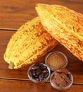 Close up of a fresh cocoa pods: dark dry cocoa bean, pieces of chocolate and powdered cocoa in crystal bowls Royalty Free Stock Photo