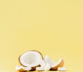 Close up fresh coconut pieces isolated on a yellow background, tropical fruit concept, flat lay, pop art, copy space Royalty Free Stock Photo