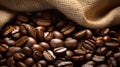 Close-up of fresh coffee beans spilling out of a sack on a rustic wooden table surface Royalty Free Stock Photo