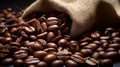 Close-up of fresh coffee beans spilling out of a sack on a rustic wooden table surface Royalty Free Stock Photo