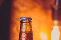 close-up of fresh cold beer ale single bottle with drops and stopper on warm background Royalty Free Stock Photo