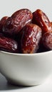 Close-up of fresh dates in white bowl against light background Royalty Free Stock Photo