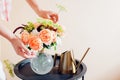 Close up of fresh english roses Lady of Shallott. Woman makes bouquet in vase of orange flowers on table at home Royalty Free Stock Photo