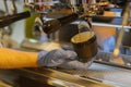 Close-up fresh espresso pours into porcelain cup in the hand of professional barista. Coffee culture and professional