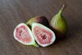 Close-up of fresh figs with one slised ripe fig on a wooden table background