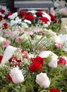 Close up of fresh floral wreaths made of pink and red roses on the grave after a funeral