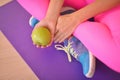 Close-up of fresh green apple held by a woman sitting at fitness class Royalty Free Stock Photo