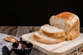 Close up fresh homemade loafs bread and sliced bread on cutting board with jam strawberry on wooden background Royalty Free Stock Photo