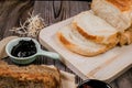 Close up fresh homemade loafs bread and sliced bread on cutting board with jam strawberry on wooden background.Healthy Diet.Prepar