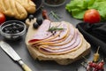 Close up fresh hum meat for sandwiches, dark board with vegetables on background.