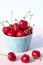 Close-up of fresh, juicy and ripe cherries in a turquoise ceramic bowl against a light background. Seasonal berries and fruits. Royalty Free Stock Photo
