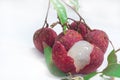 Close up of fresh lychee and peeled showing the red skin and white flesh with green leaf Royalty Free Stock Photo