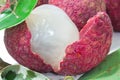 Close up of fresh lychee and peeled showing the red skin and white flesh with green leaf Royalty Free Stock Photo