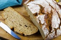 Close up of fresh made german stoneoven bread, cut slice and brown white loaf with crunchy crust on wooden cutting board Royalty Free Stock Photo