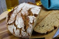 Close up of fresh made german stoneoven bread, cut slice and brown white loaf with crunchy crust on wooden cutting board Royalty Free Stock Photo