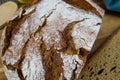 Close up of fresh made german stoneoven bread, cut slice and brown white loaf with crunchy crust on wooden cutting board Royalty Free Stock Photo