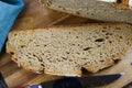 Close up of fresh made german stoneoven bread, cut slice and brown white loaf with crunchy crust on wooden cutting board Royalty Free Stock Photo