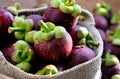 Close up fresh Mangosteens fruit in handbag on burlap background