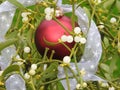 Close-up fresh mistletoe red bauble white ribbon Christmas